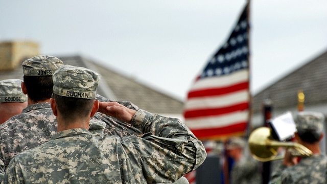 Soldiers of 1st Brigade Combat Team, 34th Infantry Division salute the American flag as the United States anthem is being played during their departure ceremony at historic Fort Snelling May 22, 2011. 1st BCT will be deploying to Kuwait in support of Operation New Dawn.