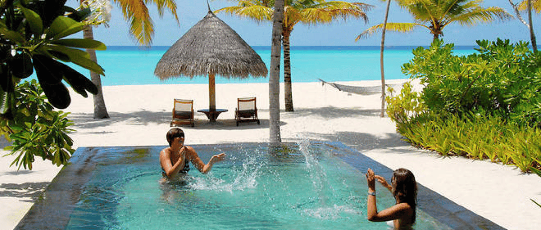 Maldives : île-hôtel avec villas sur l’eau entourant un lagon bleu clair