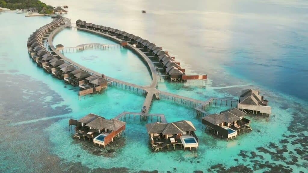Maldives : villas sur pilotis formant un cercle dans un lagon turquoise vu du ciel