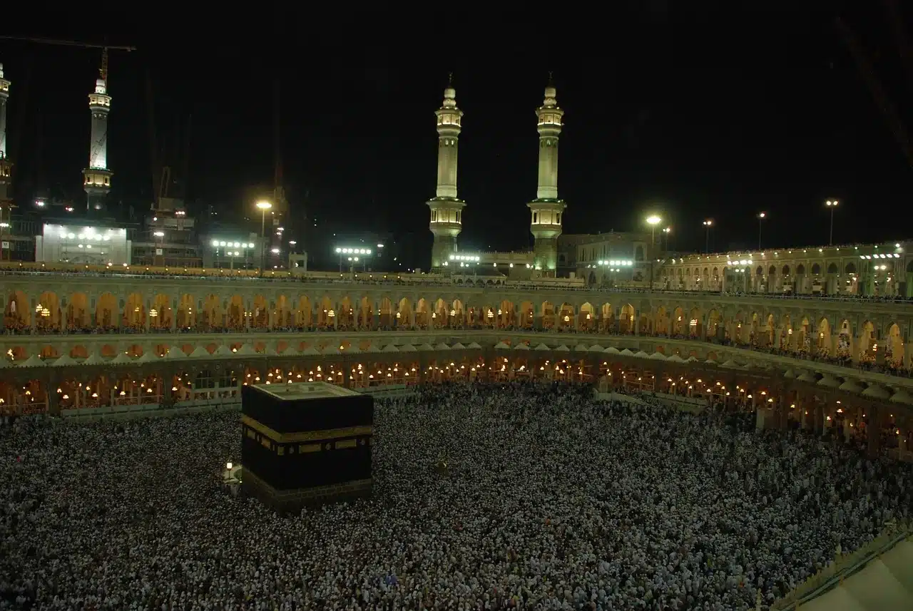 Foule de pèlerins autour de la Kaaba dans la Grande Mosquée de La Mecque durant la nuit.