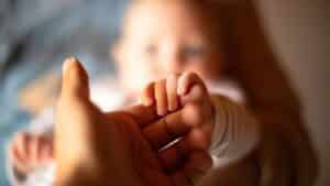 Main d’un bébé tenant celle d’un adulte, image symbolisant l’angoisse et les phobies liées à la parentalité