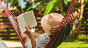 Etudiante lisant un livre dans un hamac, profitant d’un moment de détente pendant les vacances de la Toussaint.