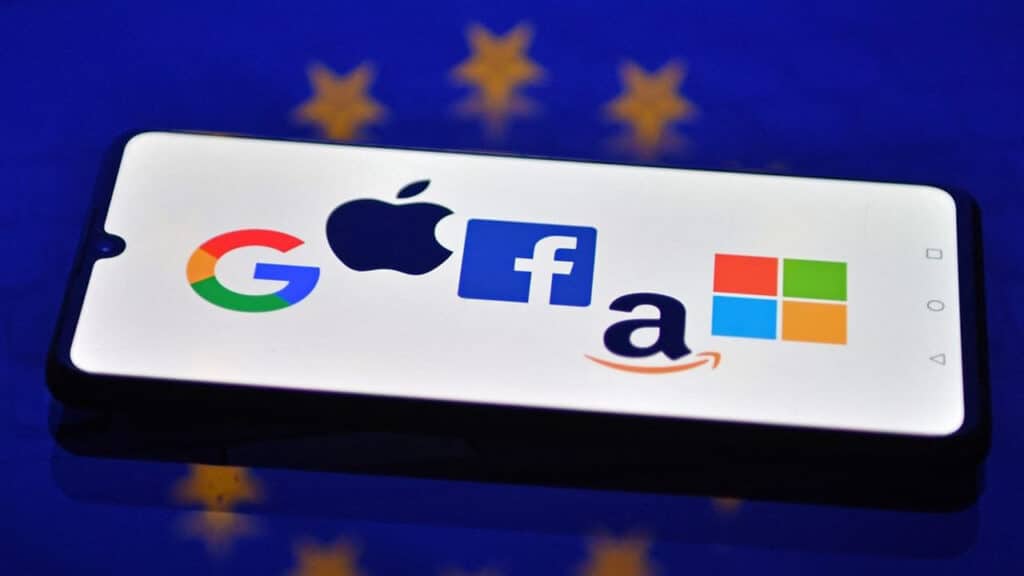Logos de Google, Apple, Facebook, Amazon et Microsoft sur fond de drapeau européen, symbolisant la bataille numérique entre l’Europe et les FTNs.