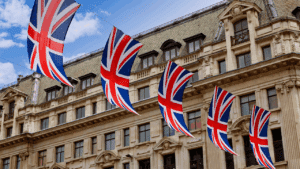 Drapeaux britanniques Union Jack suspendus devant un bâtiment londonien, illustrant les connecteurs logiques en anglais