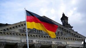 Drapeau allemand flottant devant le Bundestag, symbole des mots liaison allemand en contexte culturel.