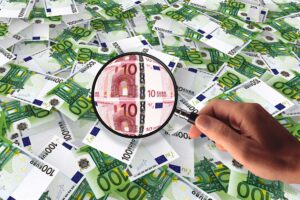 Euros sous loupe illustrant la hausse des prix liée à la greenflation.