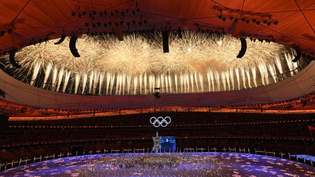 Feux d’artifice lors de la cérémonie d’ouverture des Jeux Olympiques de Pékin, symbolisant la grandeur et la mise en scène mondiale.