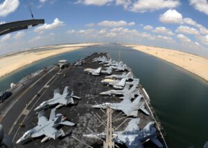 Porte-avions militaire traversant le canal de Suez, reliant la Méditerranée et la mer Rouge, illustrant l’importance géostratégique et commerciale de cette route maritime internationale.