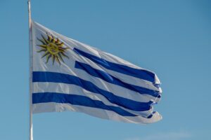 Drapeau de l’Uruguay flottant au vent, symbole d’un pays laïque, démocratique et socialement avancé, incarnant les valeurs de sobriété et de cohérence politique portées par José “Pepe” Mujica.