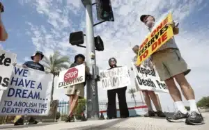 Des manifestants tiennent des pancartes contre la peine de mort lors d’un rassemblement, appelant à son abolition aux États-Unis.