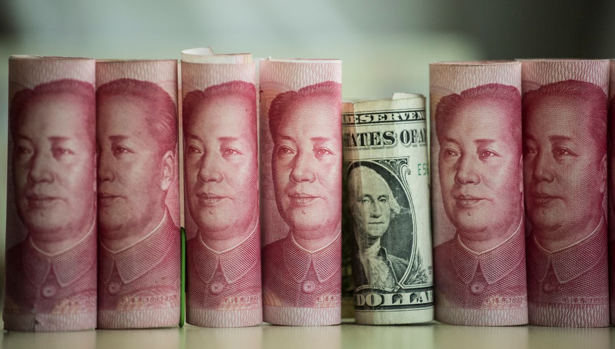 Billets de yuan chinois entourant un billet de dollar américain, symbolisant la rivalité monétaire et la géopolitique du yuan face au dollar.