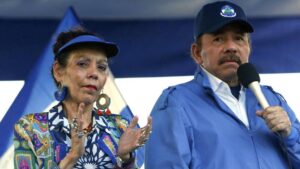 Deux responsables politiques s’expriment lors d’un rassemblement au Nicaragua, l’un tenant un micro, l’autre applaudissant.