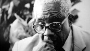 Portrait en noir et blanc d’Aimé Césaire, le visage partiellement masqué par un menu déroulant sur l’écran.