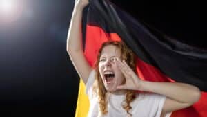 Jeune femme rousse criant avec un drapeau allemand, incarnation du féminisme allemand
