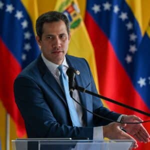 Juan Guaidó, figure de l’opposition vénézuélienne, s’exprimant lors d’une conférence de presse devant des drapeaux du Venezuela.