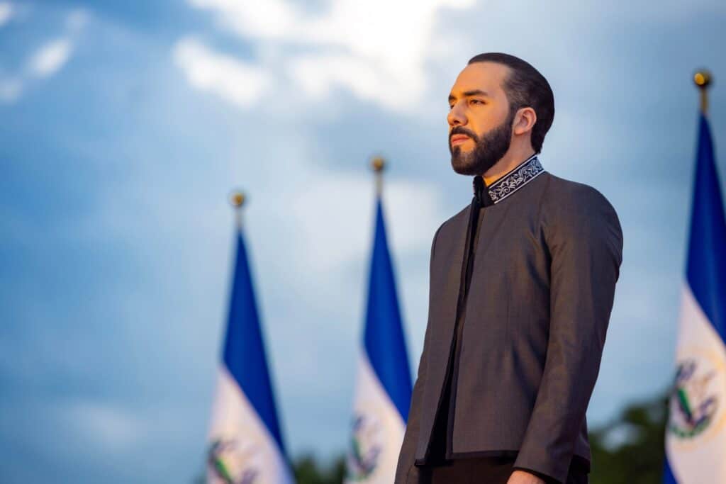 Président salvadorien lors d’une cérémonie officielle, devant des drapeaux nationaux.