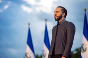 Président salvadorien lors d’une cérémonie officielle, devant des drapeaux nationaux.