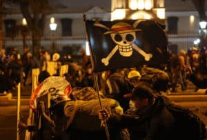 Manifestants brandissant un drapeau pirate lors de manifestations nocturnes au Pérou.