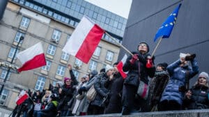 Manifestation en Pologne avec drapeaux polonais et européens, illustrant les tensions avec l’UE