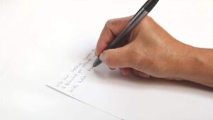 Étudiant rédigeant des transitions en dissertation de géopolitique sur une feuille de brouillon.