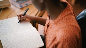 Une personne écrit dans un carnet, illustration de la pratique de who ou which en anglais