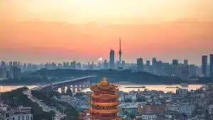 Skyline chinoise au coucher de soleil avec temple traditionnel au premier plan, paysage urbain et culturel de Chine