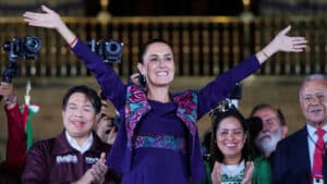 Claudia Sheinbaum levant les bras en signe de victoire, entourée de partisans lors de son élection