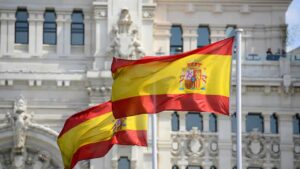 Deux drapeaux espagnols flottant devant un palais de Madrid, illustration de la concordance des temps en espagnol