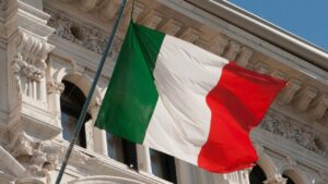 Drapeau italien flottant devant un palais historique, symbole de l'unité nationale de l'Italie