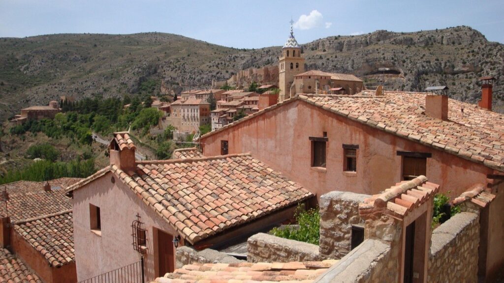 Village médiéval aux toits de tuiles dans une vallée aride, symbole de l'Espagne vide