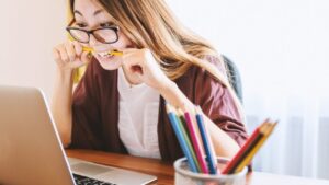 Étudiante concentrée devant son ordinateur réalisant des exercices de conjugaison espagnole