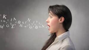 Femme parlant avec des lettres sortant de sa bouche, illustrant l'apprentissage des expressions espagnoles