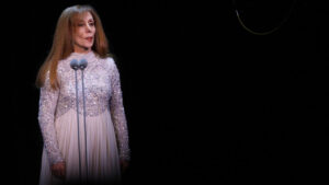 Chanteuse arabe sur scène, en robe scintillante devant un microphone