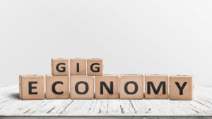 Cubes en bois formant les mots "Gig Economy", illustration du concept de gig economy