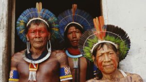 Trois membres d'un peuple indigène en coiffes de plumes, illustration des peuples indigènes en Amérique latine