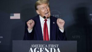 Donald Trump devant un pupitre "America First Agenda" illustrant l'isolationnisme et l'interventionnisme américain
