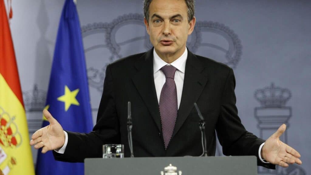 José Luis Rodríguez Zapatero s'exprimant lors d'une conférence de presse officielle, drapeaux espagnol et européen en arrière-plan