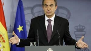 José Luis Rodríguez Zapatero s'exprimant lors d'une conférence de presse officielle, drapeaux espagnol et européen en arrière-plan