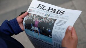 Une personne tenant un exemplaire d'El País, l'un des principaux médias espagnols