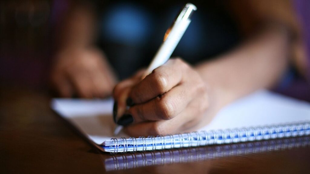 Étudiant préparant sa colle en espagnol en prenant des notes sur un carnet