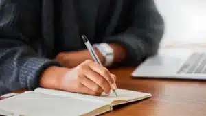 Étudiant prenant des notes à la main pour préparer la synthèse de textes au concours BCE