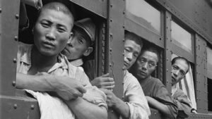 Hommes japonais regardant par les fenêtres d'un train, photographie d'époque illustrant l'occupation américaine au Japon