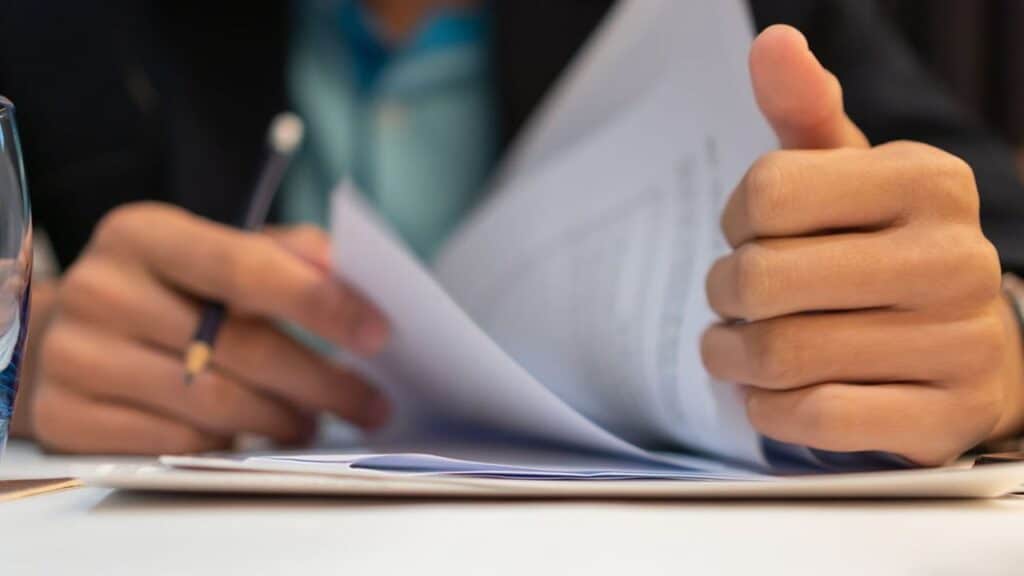 Mains feuilletant des documents illustrant comment présenter un document en anglais