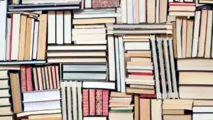 Étagère de livres anciens en bibliothèque, illustrant l'apprentissage du prétérit ou present perfect en grammaire anglaise