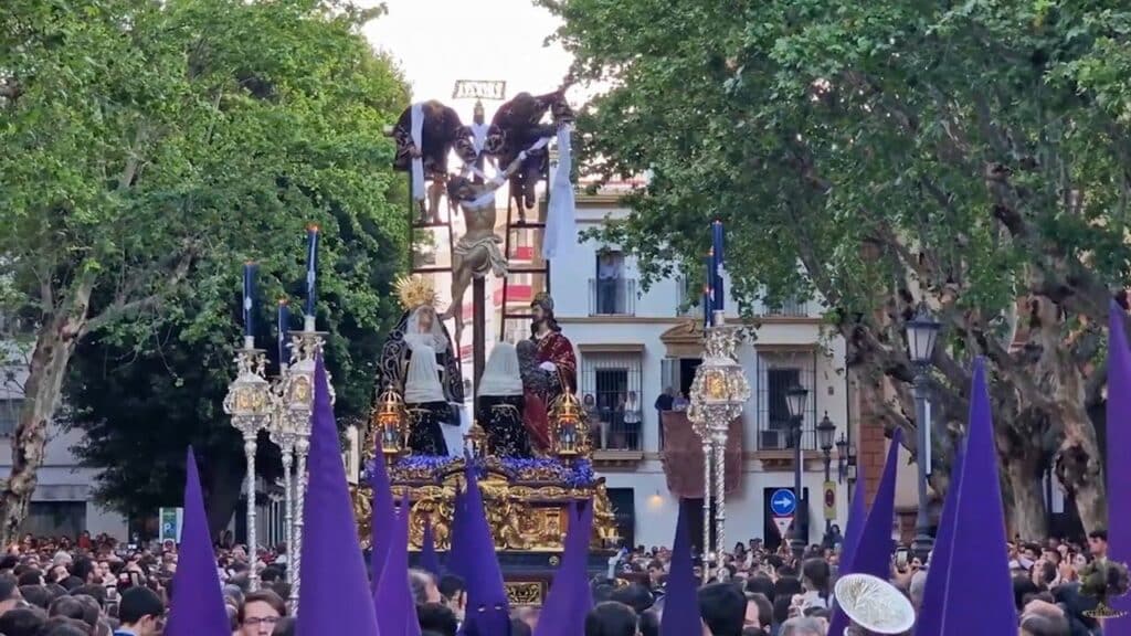 Procession de la Semana Santa en Espagne avec un paso représentant la crucifixion, entouré de nazarenos en capirote violet