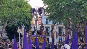 Procession de la Semana Santa en Espagne avec un paso représentant la crucifixion, entouré de nazarenos en capirote violet