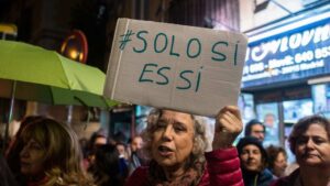 Manifestante brandissant une pancarte "Solo sí es sí" lors d'une manifestation féministe en Espagne
